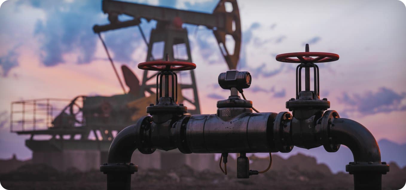 Válvulas de un oleoducto con una bomba de balancín al atardecer