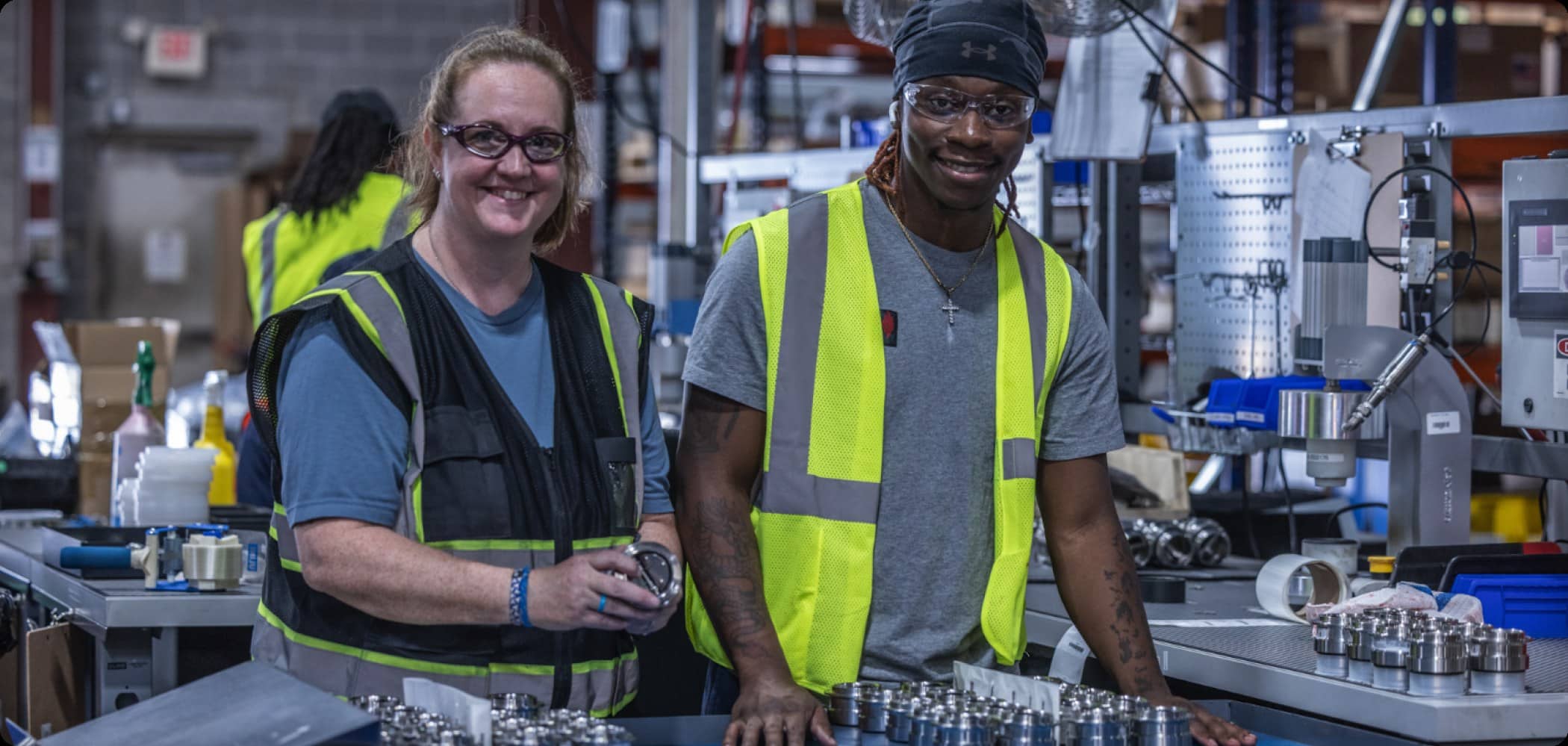 Two smiling US Valve production team members in safety vests